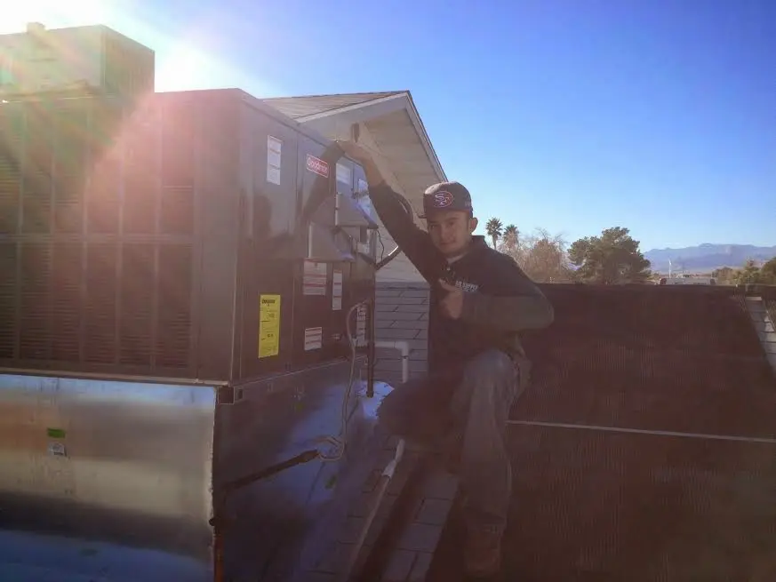HVAC technician performing Boiler Repair on a rooftop unit in North Ogden